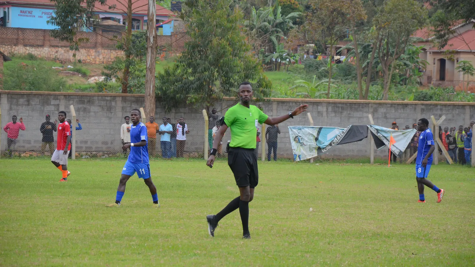 Arbitre en action pendant un match de football, vu sur la pelouse